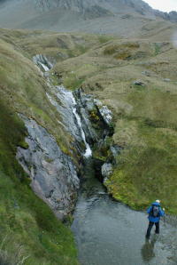 Crossing below waterfall